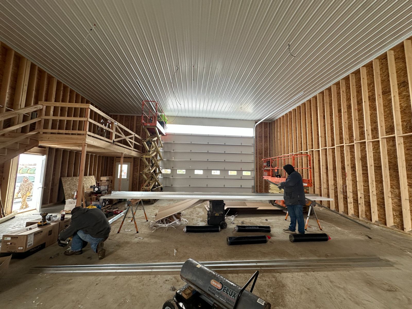 Prairie Barns crew working inside a heated shop under construction in winter, Dickinson North Dakota.